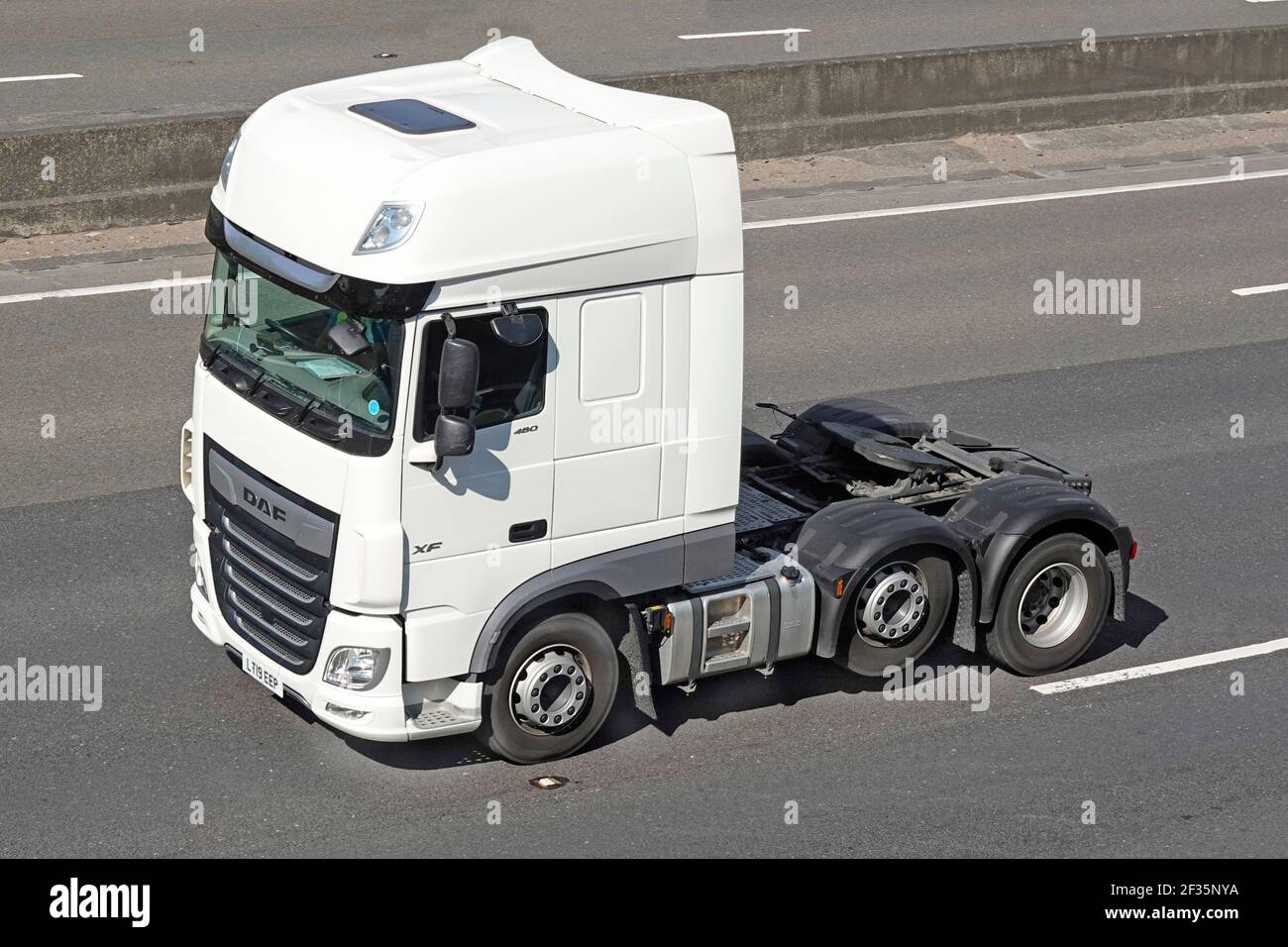 Front & side view cab white clean DAF brand of solo semi truck tractor unit prime mover twin rear axle lorry one tyre economy raised on UK motorway Stock Photo