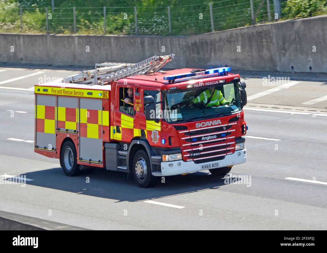 Essex County Fire brigade service crew heavy rescue Angloco fire engine on Scania chassis 999 emergency call driving on M25 motorway to RTA England UK Stock Photo