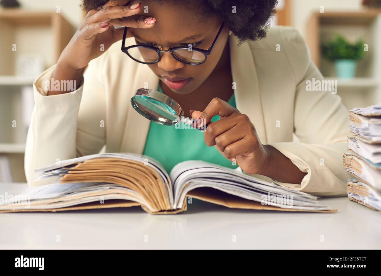 Closeup concentrated african american auditor scrutinizing financial documents Stock Photo