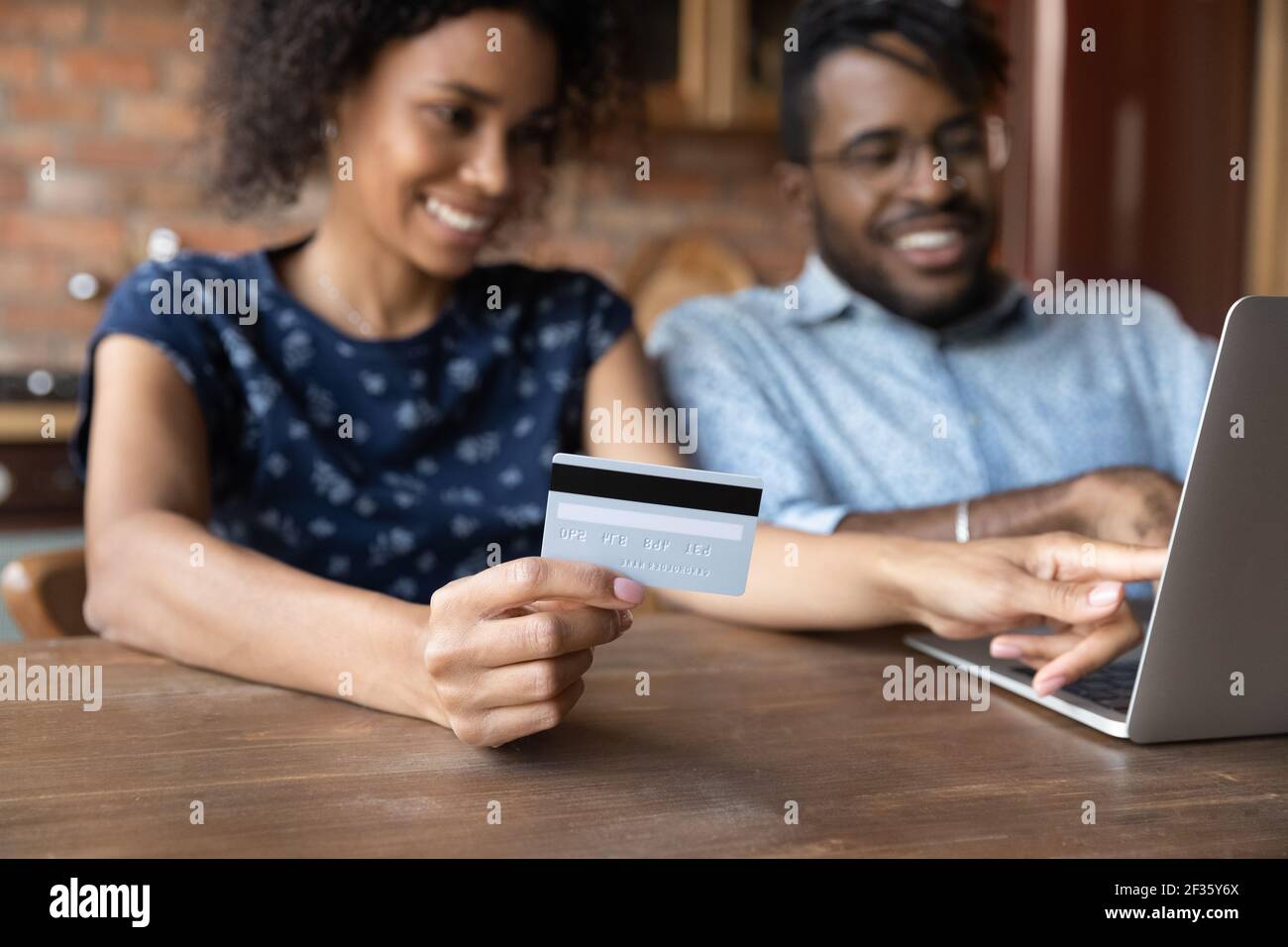 Millennial afro american spouses sit by laptop make cashless payment Stock Photo