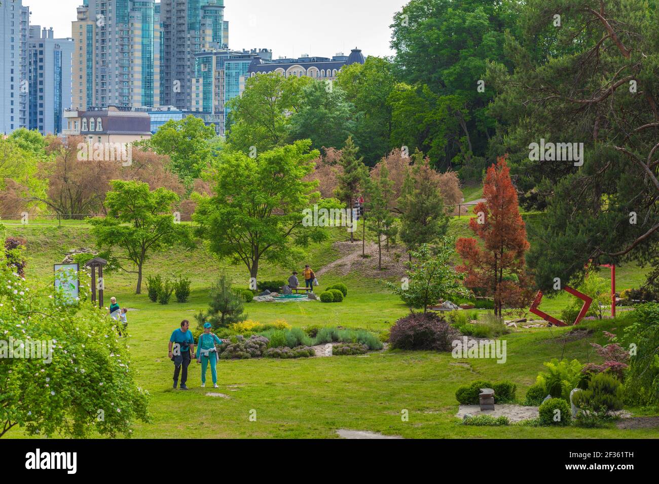 Kiev, Ukraine - June 5, 2020: Botanical Garden N.N. Grishko Kiev. People walk in the park on a clear summer day. In the background are multi-story urban buildings. High quality photo Stock Photo