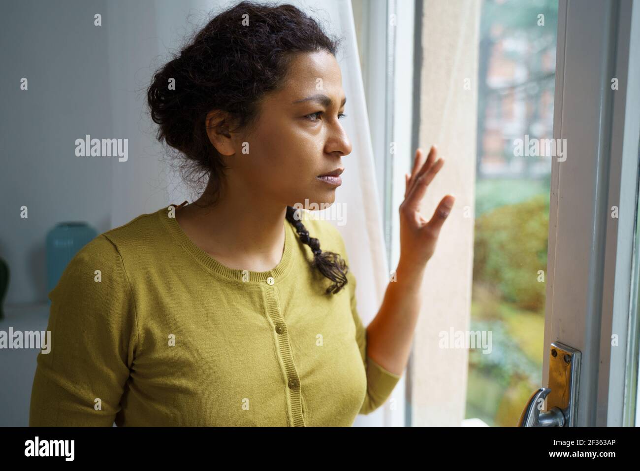 Worried black woman looking out of the window Stock Photo