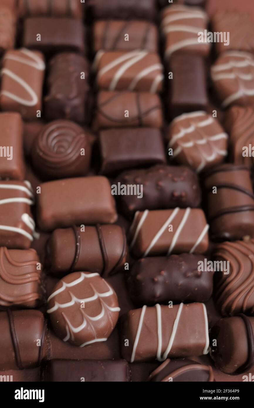 Chocolates assortment set.Chocolate sweets.Chocolate pattern. Candy close-up on a brown background.dark milk chocolates .Set of different chocolates Stock Photo