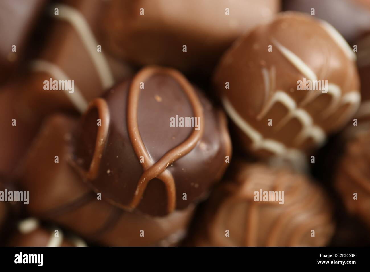 Chocolates assortment set.Chocolate sweets.Chocolate pattern. Candy on a brown background.dark milk chocolates .Set of different chocolates.Sweet Stock Photo