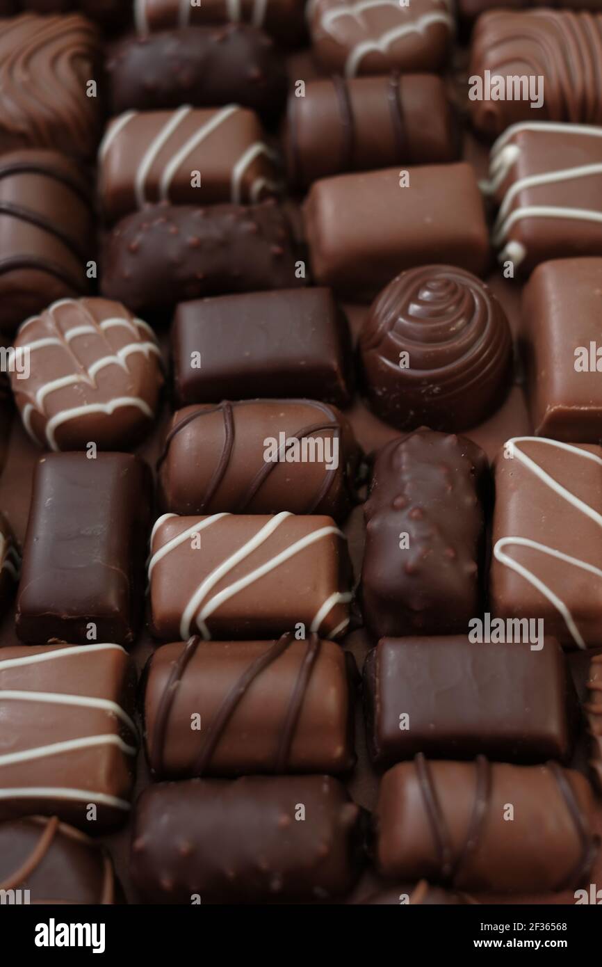 Chocolates assortment .Chocolate sweets.Chocolate pattern. Candy close-up on a brown background.dark milk chocolates .Set of different chocolates Stock Photo