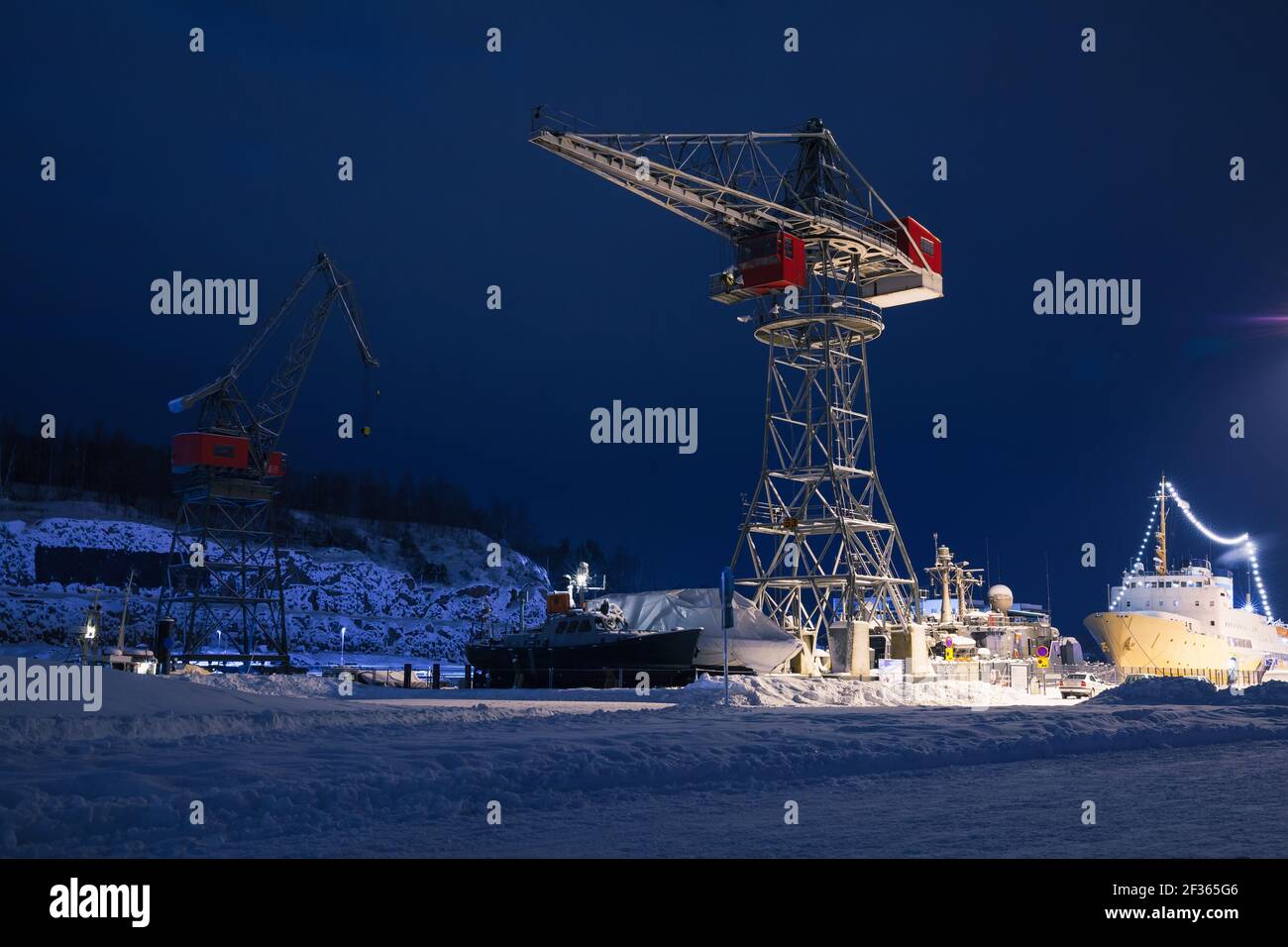 Industrial cranes and cargo ships are in port of Turku at night, Finland Stock Photo