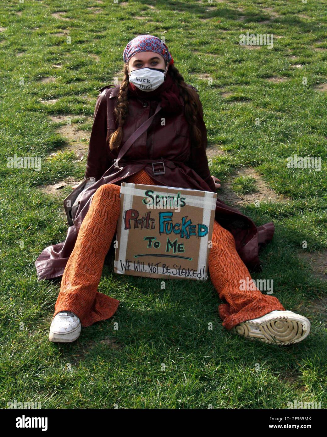 London, UK. 15th Mar, 2021. Protester sits on the grass, waiting for the event to begin with a sign opposing Priti Patel's new right to protest law. London. 15th March 2021. Credit: One Up Top Editorial Images/Alamy Live News Stock Photo