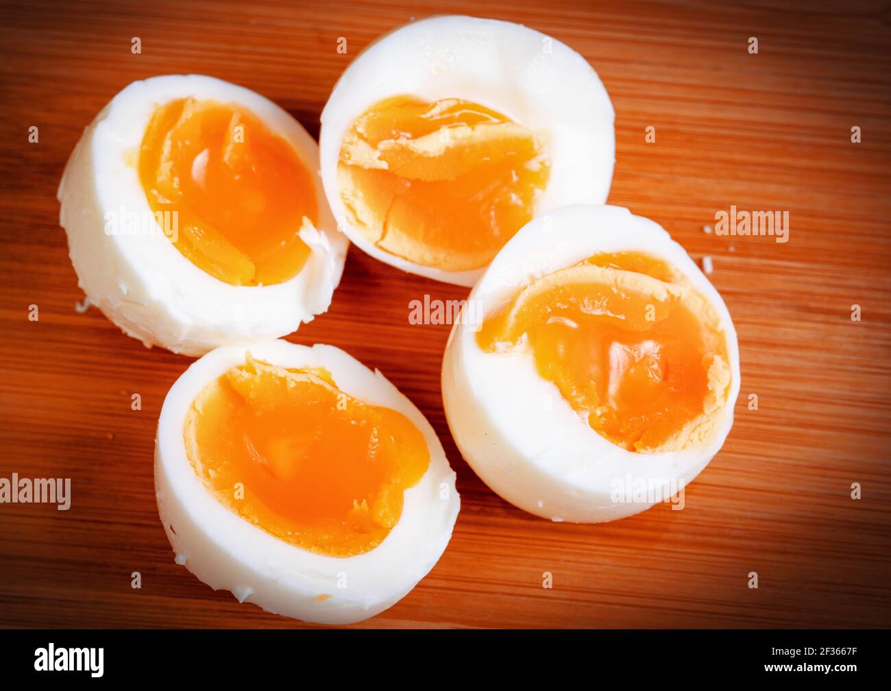 Halved eggs cooked semi-hard, tasty snack. Stock Photo