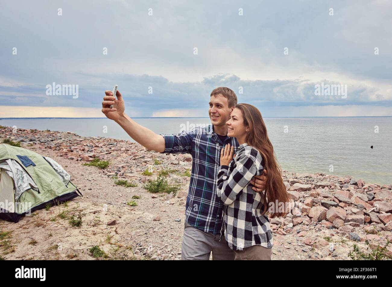 Young couple hiking taking selfie with smart phone. Happy young man and ...