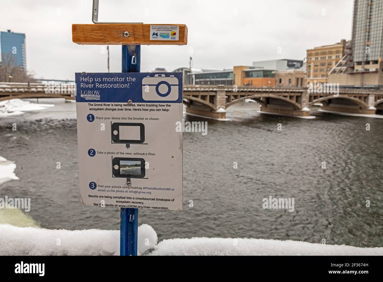 Grand Rapids, Michigan - A sign urges pedestrians to take photographs to document the restoration of the Grand River. The restoration plan calls for r Stock Photo