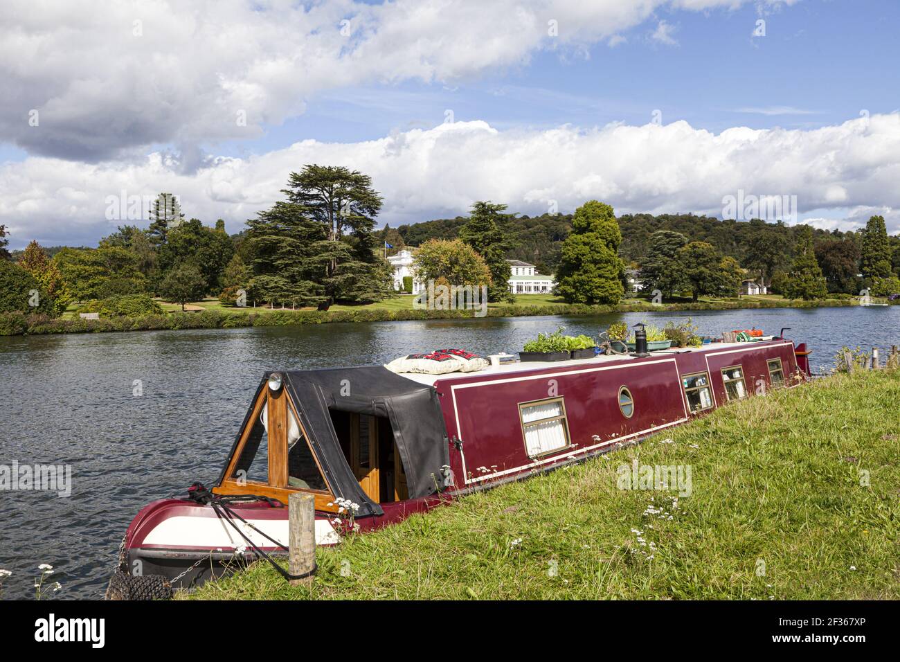 A narrow boat moored opposite Greenlands on the River Thames at Hambleden, Buckinghamshire, UK Stock Photo