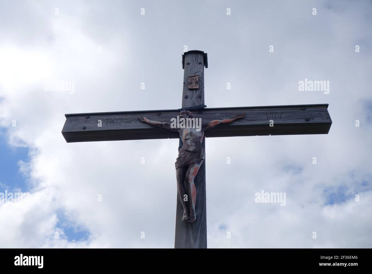 A low angle shot of Jesus Christ on the Cross against a cloudy sky ...
