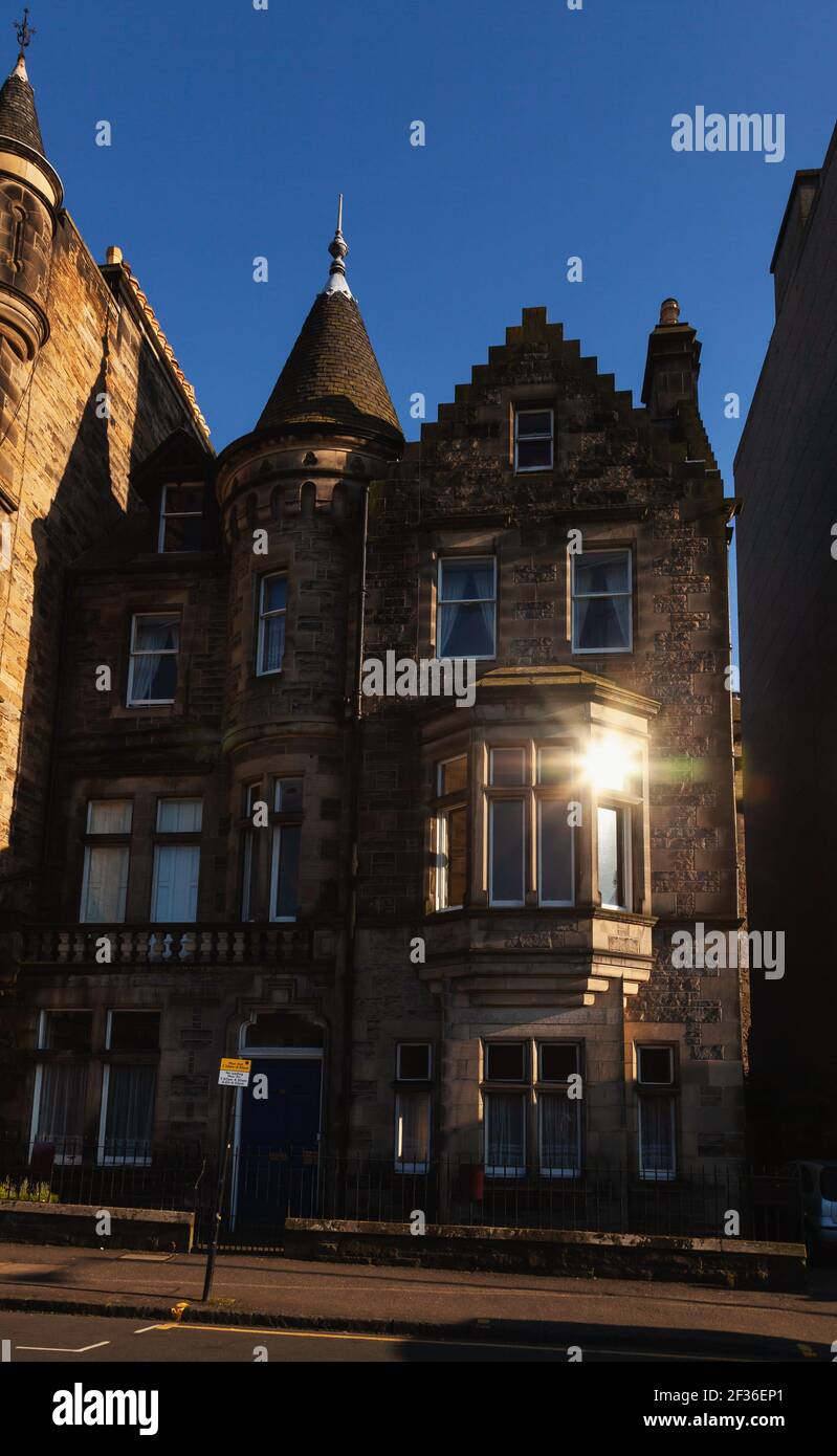 Setting sun reflects in a window of typical town house in Edinburgh