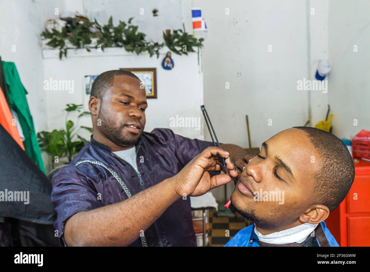 Santo Domingo Dominican Republic,Ciudad Colonia Zona Colonial,Calle Jose Reyes barbershop Hispanic Black man barber working shaving,customer, Stock Photo