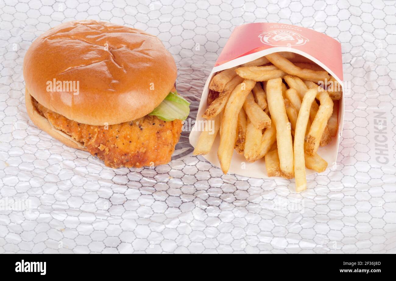 Wendy's Spicy Chicken Sandwich on Wrapper with French Fries or Chips Stock Photo