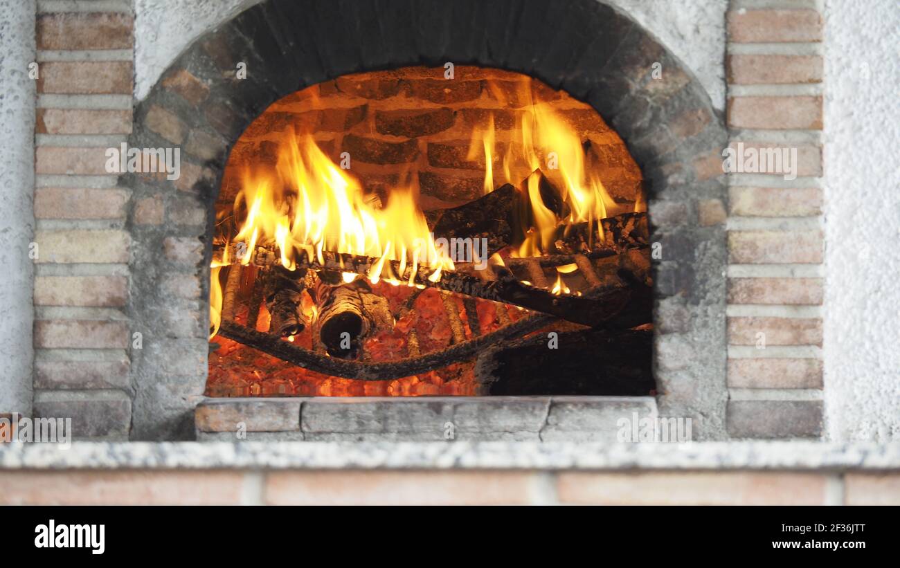 An atmospheric view of a fireplace with blazing fire Stock Photo