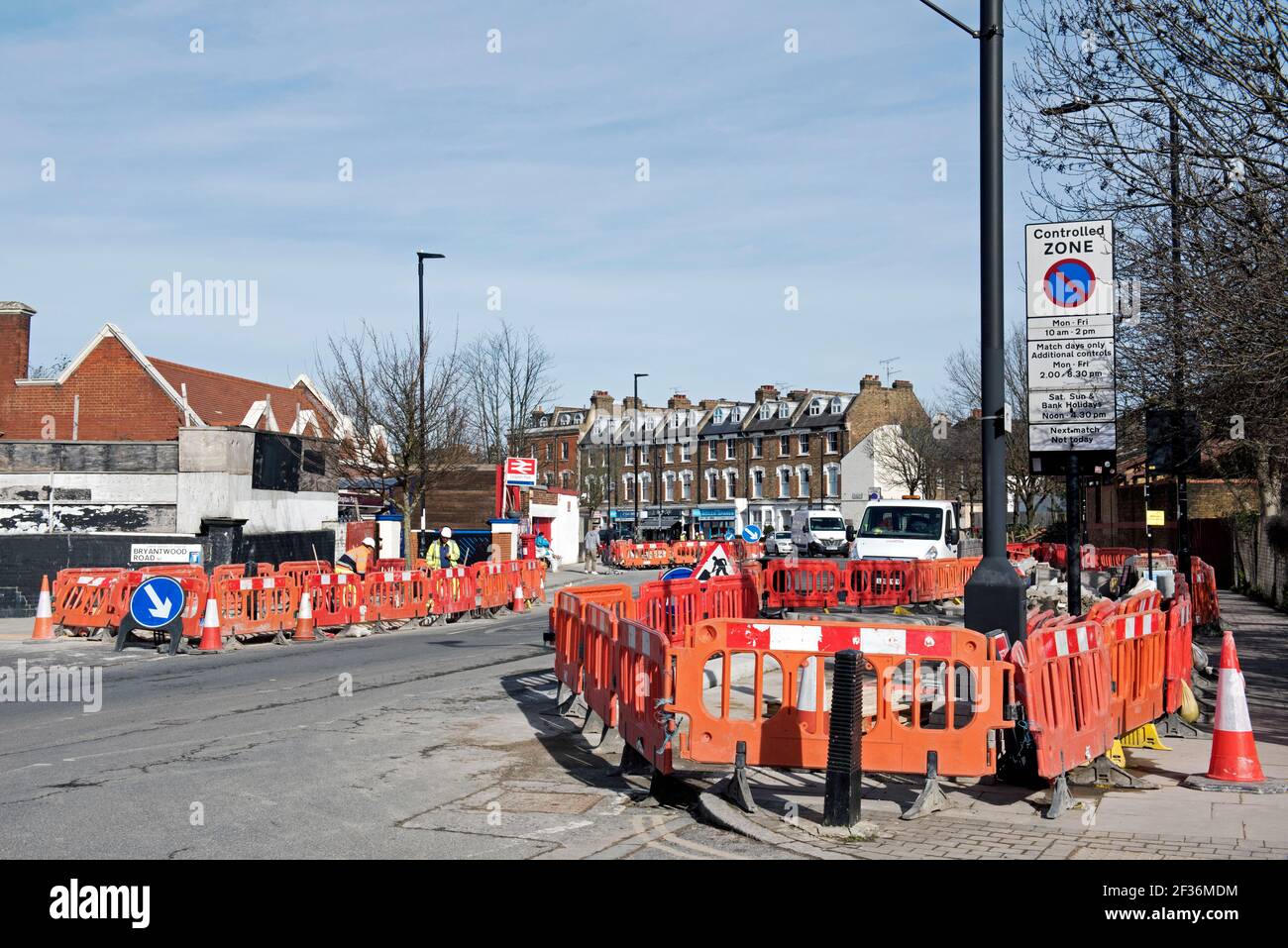 Road Works with orange barriers and workmen constructing cycle lanes part of the low traffic neighbourhood scheme Drayton Park Highbury Stock Photo