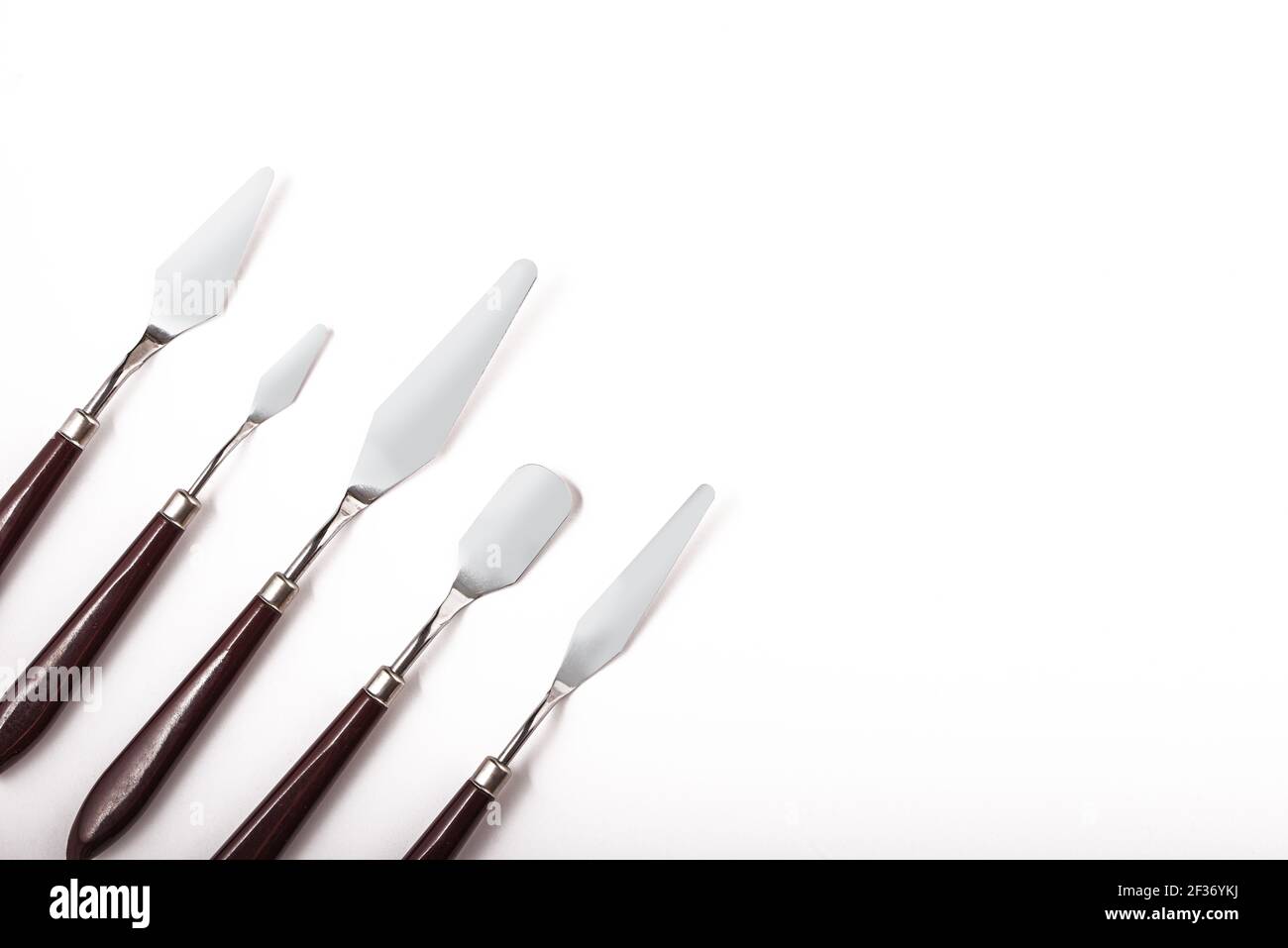 Five art palette knives lie on a white background.Stainless steel