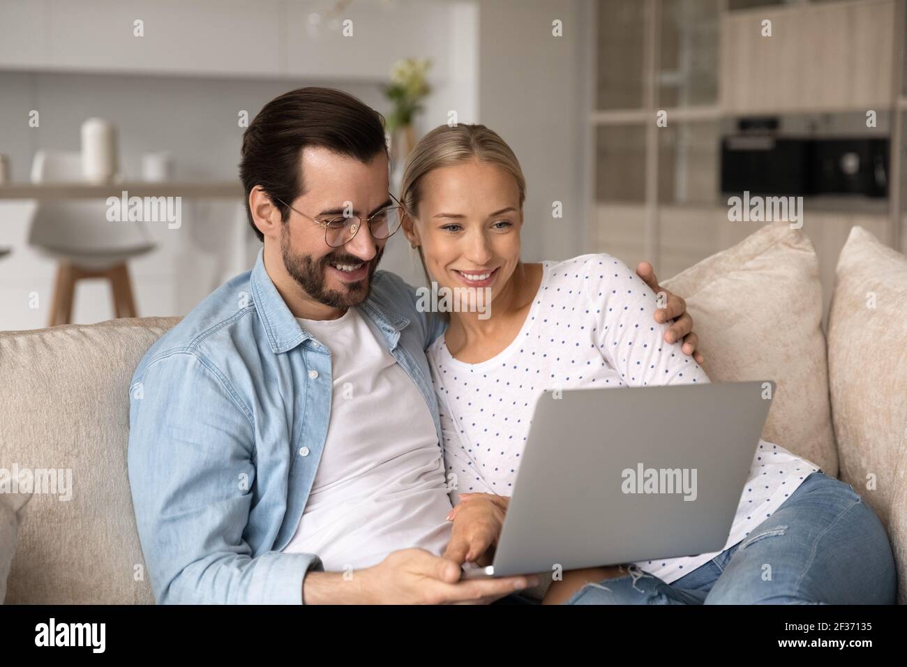 Smiling young couple relax together using laptop Stock Photo
