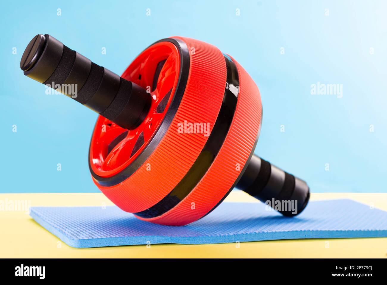Ab roller, abdominal roller exercises, abdominal strength trainer on a mat on a blue background