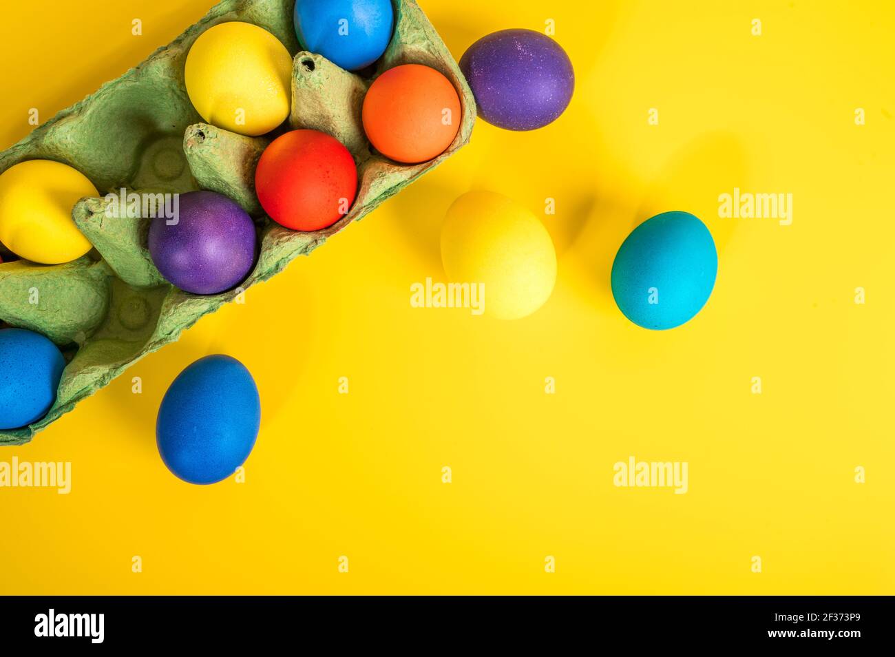 Multi-colored Easter eggs in an egg tray. Minimal concept Stock Photo