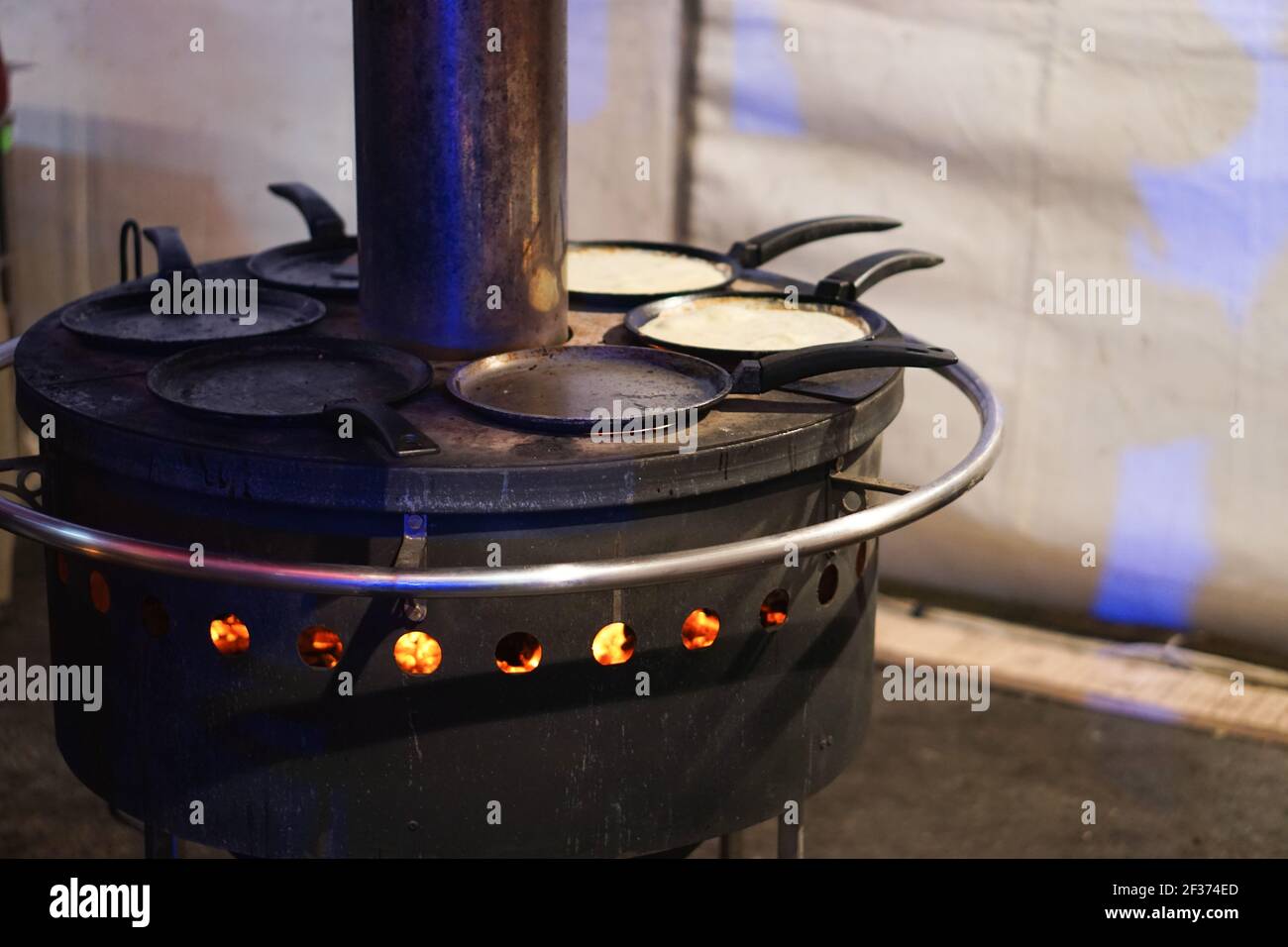 https://c8.alamy.com/comp/2F374ED/industrial-traditional-open-fire-pancake-maker-for-few-frying-pans-at-ukrainian-bazaar-high-quality-photo-2F374ED.jpg