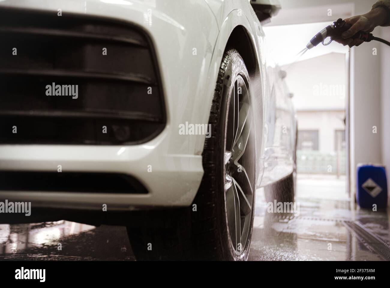 manually wash car wheels using pressure hoses with water Stock Photo