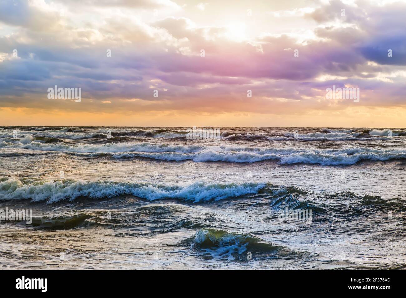 beautiful sunset in the cloudy sky above the stormy sea Stock Photo - Alamy