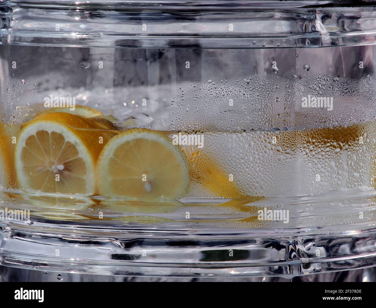 A large glass container of water with lemons. Stock Photo