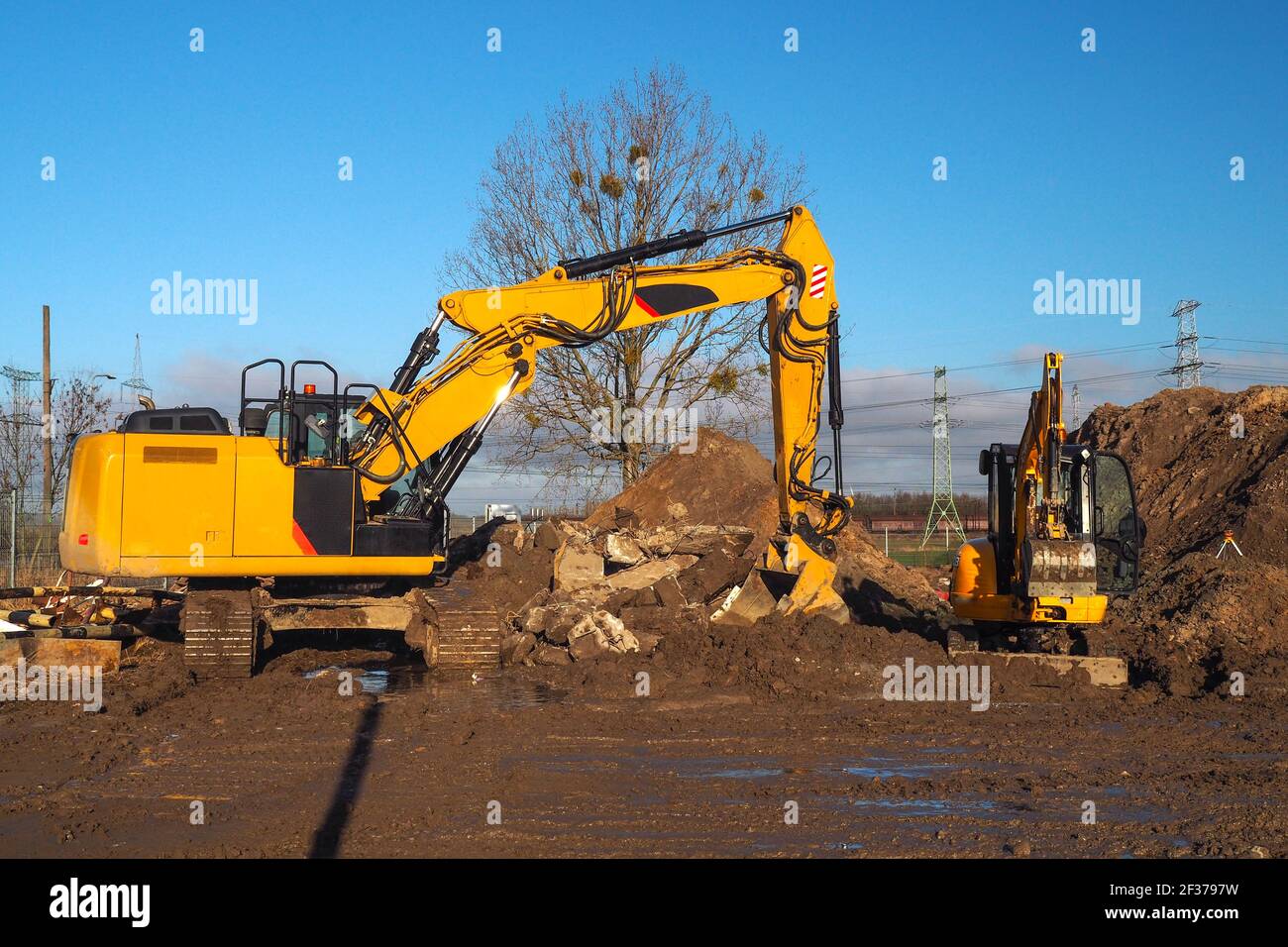 two yellow excavators are tidying up the construction site Stock Photo ...