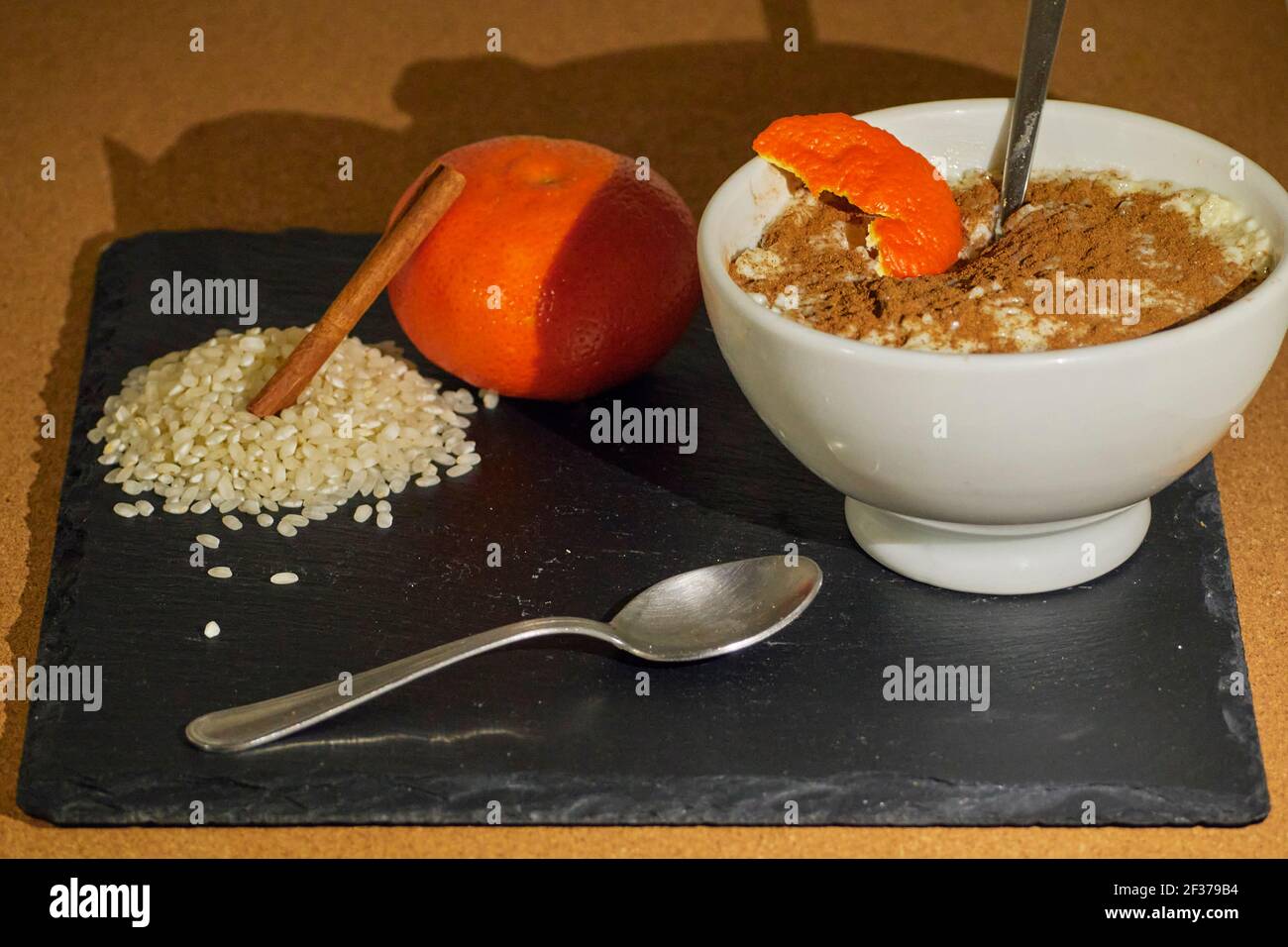 Rice pudding with tangerine peel on black slate board decorated with ...
