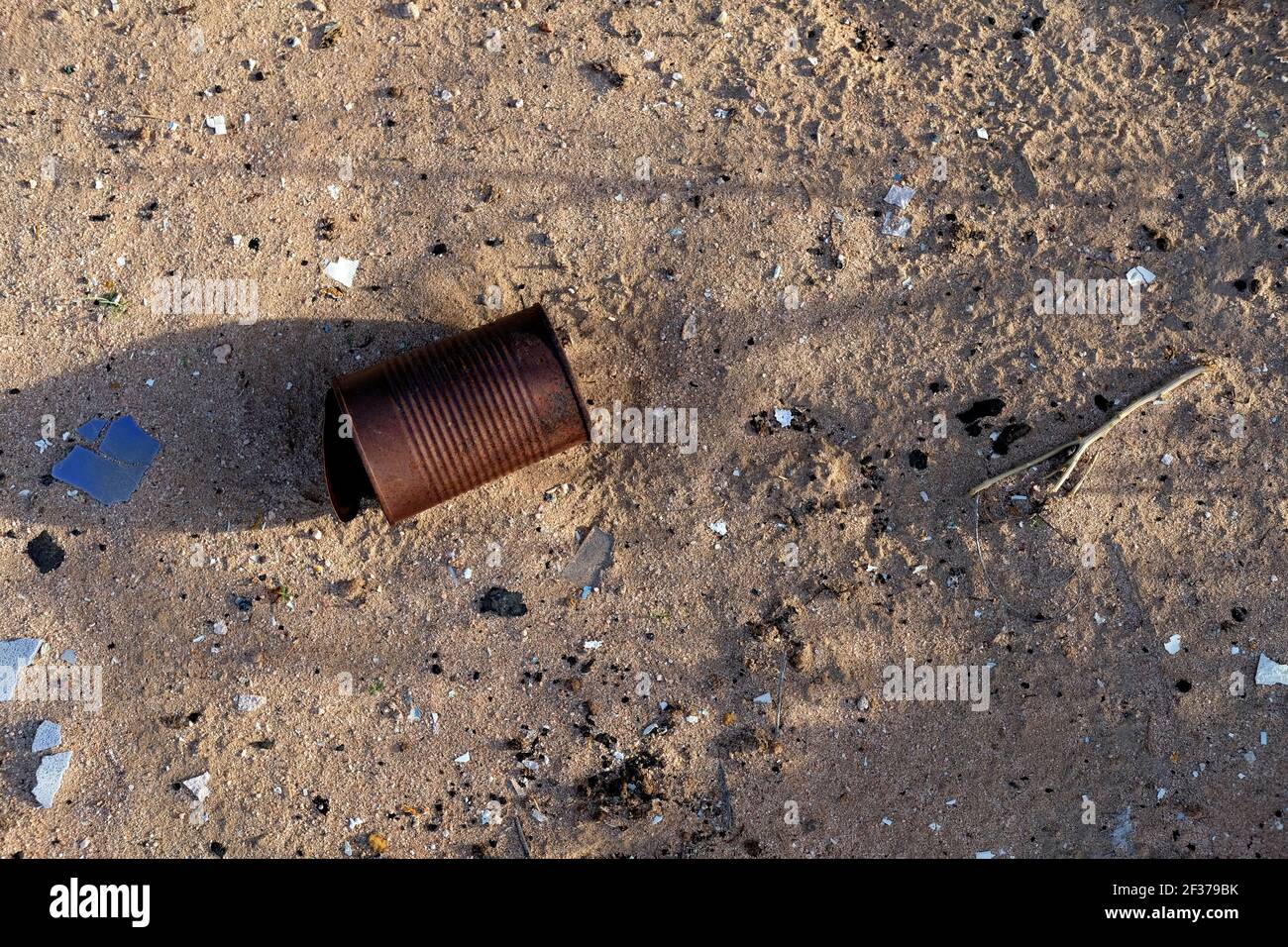Corroded tin can on the ground; ravages of time on modern civilization; rust and aging; effects of metal exposed to oxygen and moisture over time. Stock Photo