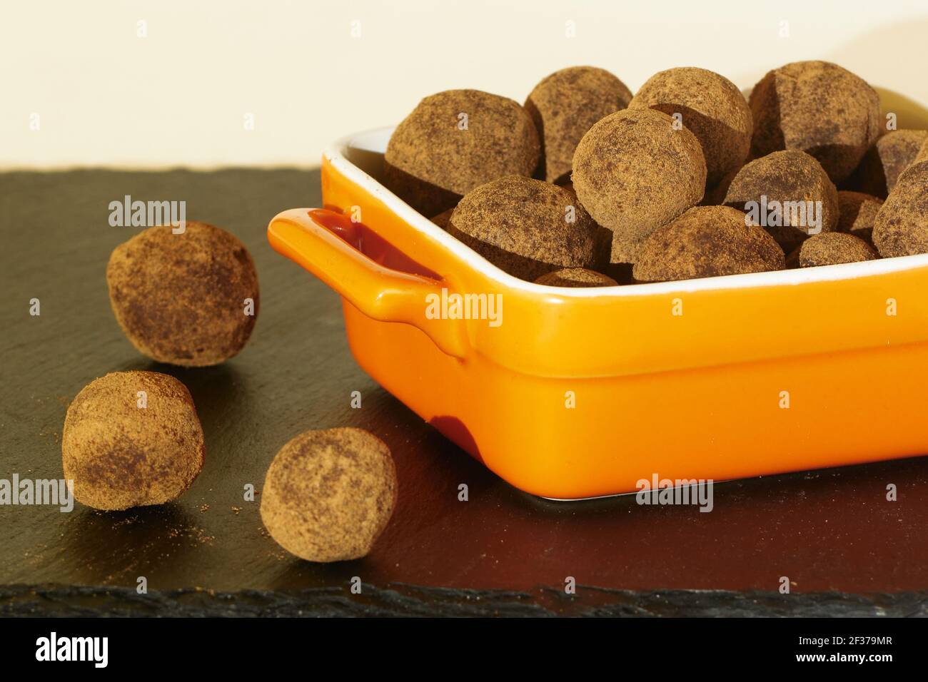 Truffles in ceramic square ramekin on black slate board Stock Photo Alamy