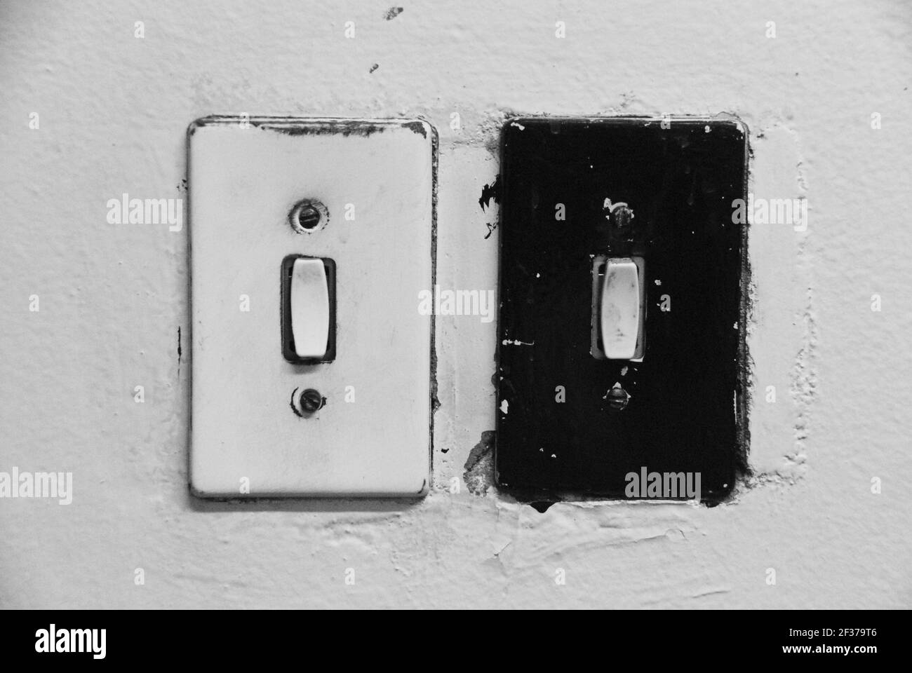 Black and White vintage light switches on white wall Stock Photo