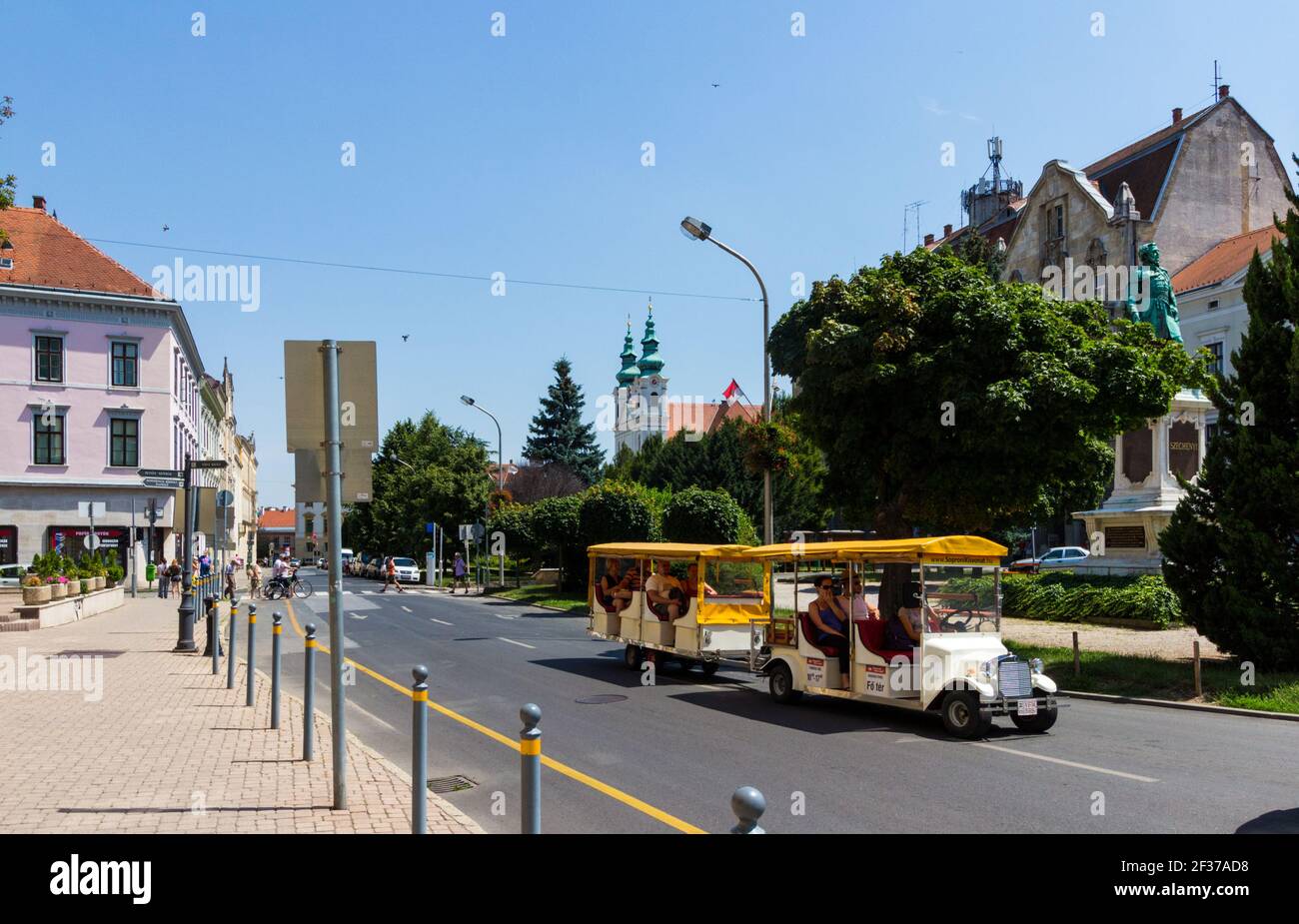 Szechenyi ter (Square) with sightseeing street train and the Saint Jude Thaddeus Church (Domonkos-templom), Sopron, Hungary Stock Photo