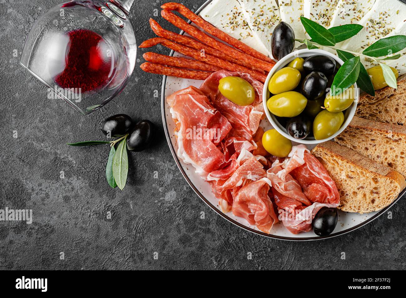 Italian antipasto plate with red wine on dark background. Top view, copy space. Stock Photo