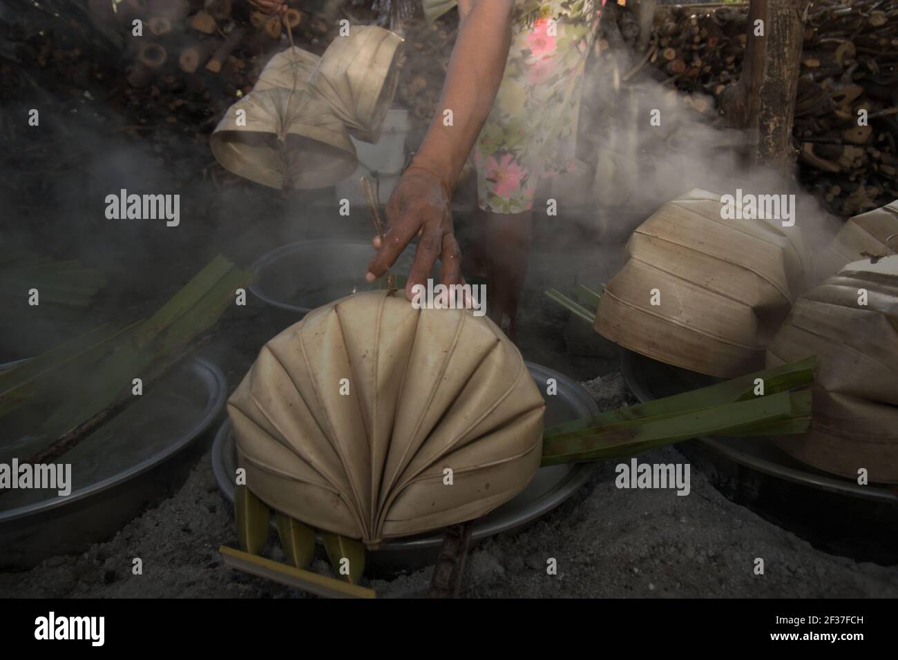 A woman boiling palm sap to make palm sugar, an alternative source of income for villagers living in Rote Island, Indonesia. Stock Photo