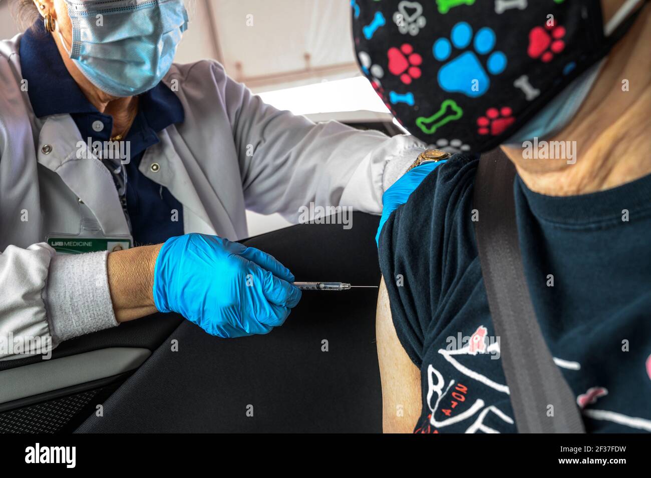 A nurse prepares to administer at a  Covid 19 Vaccine to a 74 year old woman at a drive-thru  distribution center in Hoover, Alabama organized by the university of Alabama, Birmingham, UAB. Stock Photo