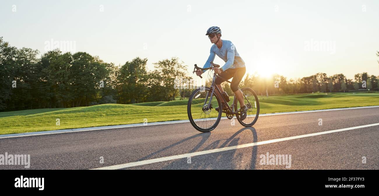 Full length shot of professional male racer in sportswear and helmet ...