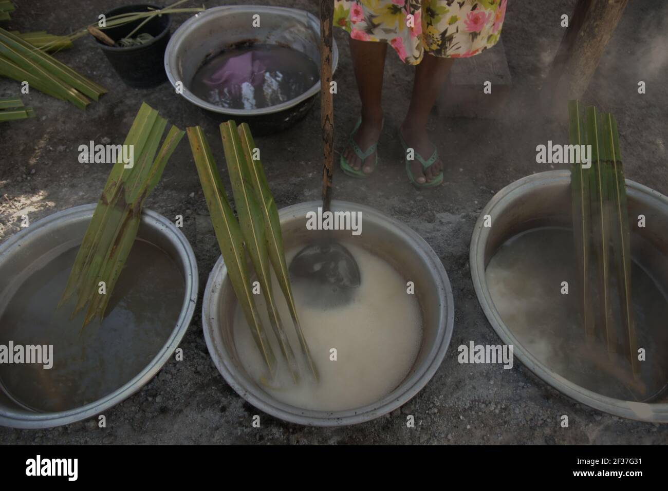 A woman boiling palm sap to make palm sugar, an alternative source of income for villagers living in Rote Island, Indonesia. Stock Photo