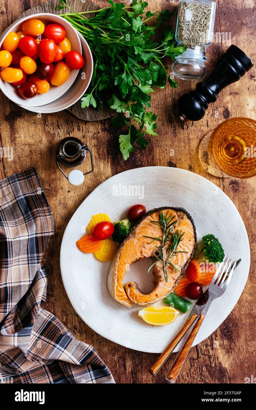 grilled salmon steak with vegetables on a wooden table Stock Photo