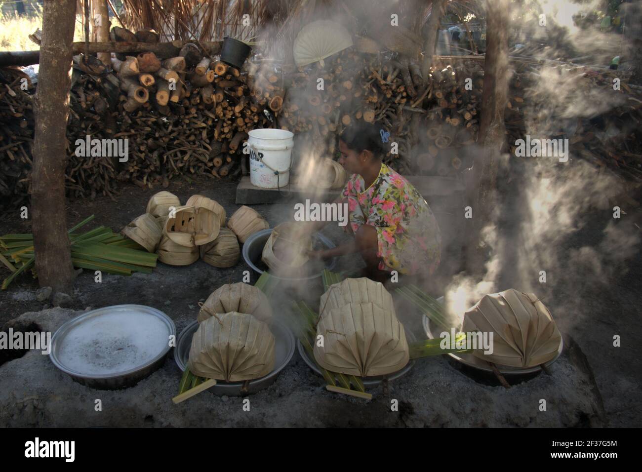 A woman boiling palm sap to make palm sugar in Oehandi village, Rote