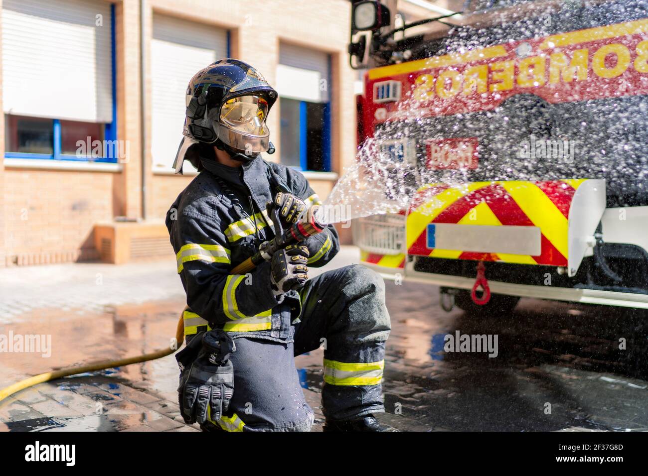 firefighter pouring water to extinguish a fire Stock Photo Alamy