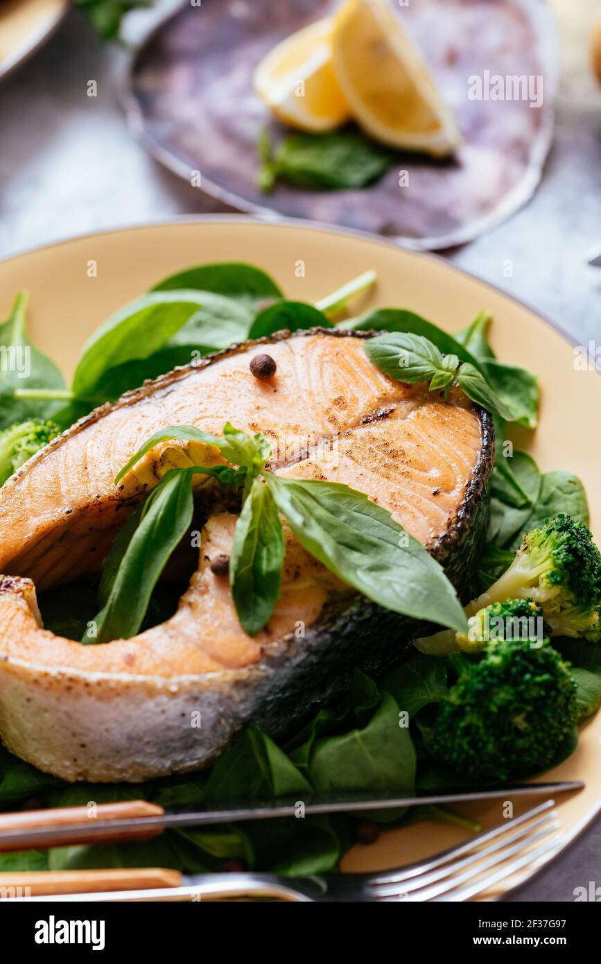 grilled salmon steak with vegetables on a marble table Stock Photo