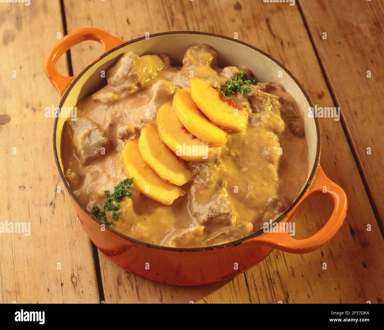 Beef stew with peach slices on wooden table, Winkfield, Berkshire, England, United Kingdom Stock Photo