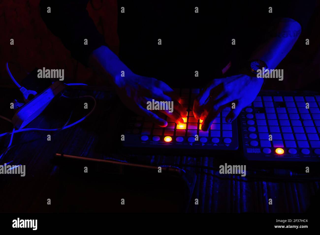 DJ playing synthesizer and mixing music in the night club Stock Photo