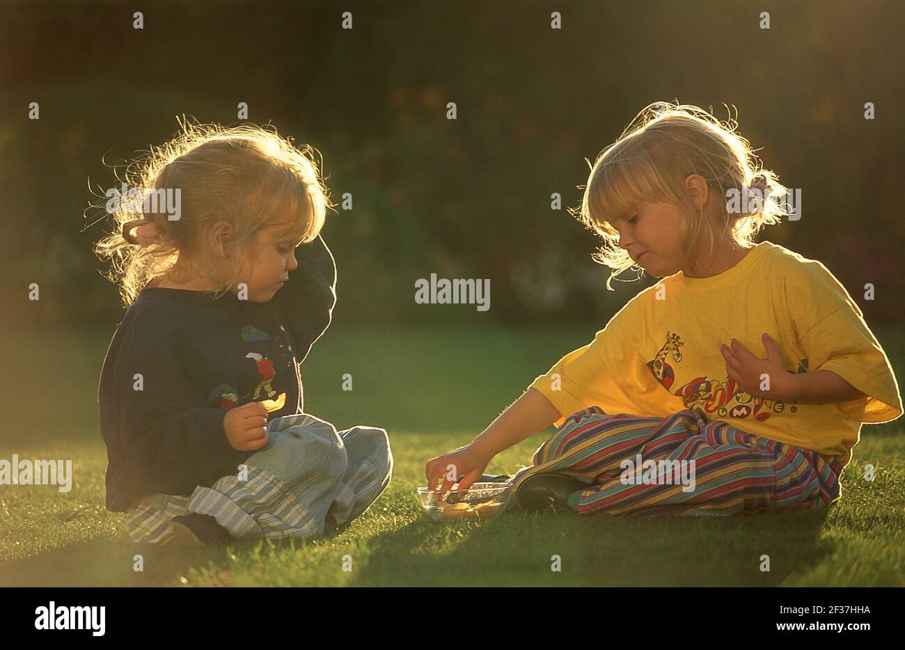 Young girls eating crisps outdoors, Winkfield, Berkshire, England, United Kingdom Stock Photo