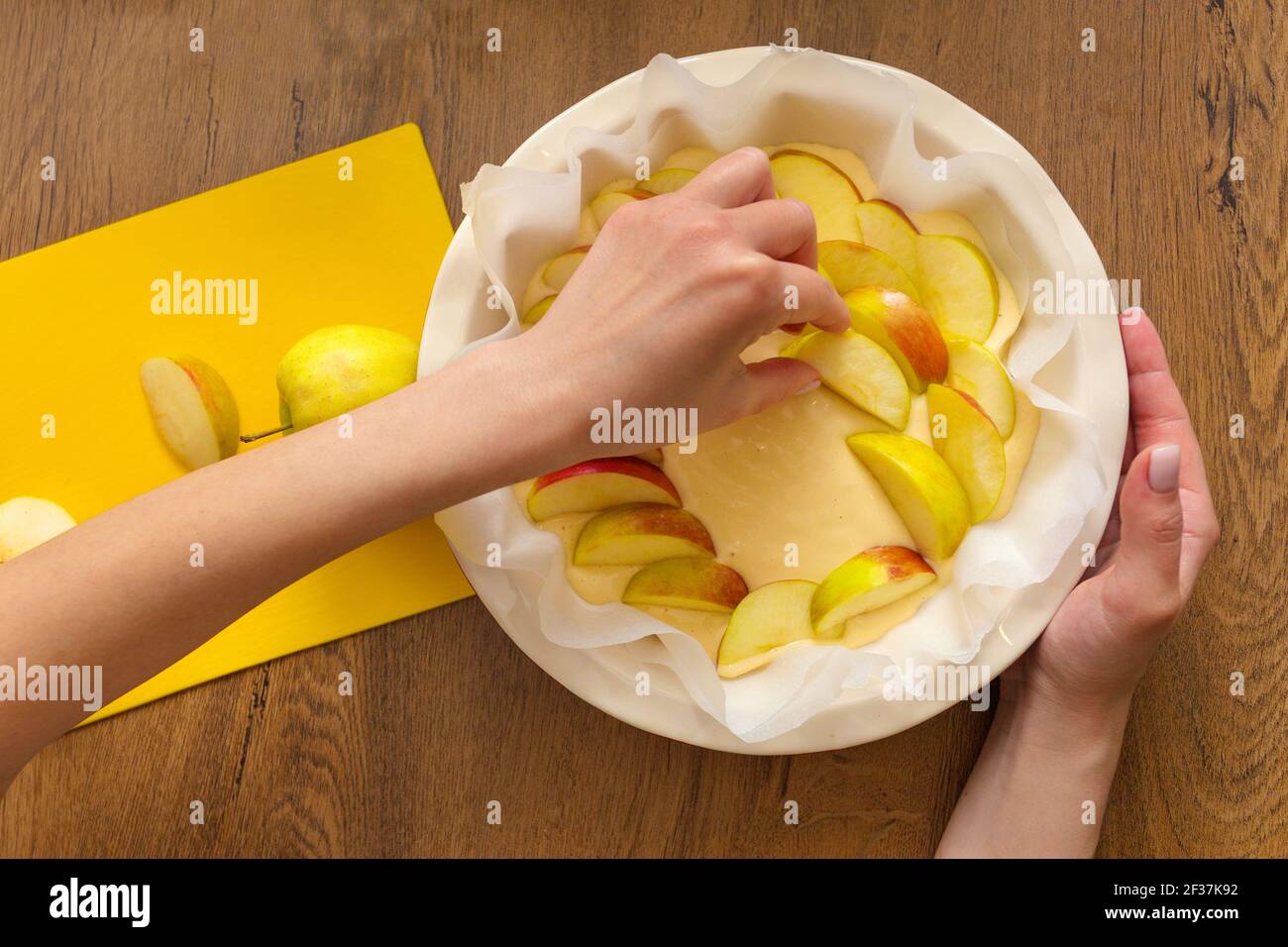 The hostess at home is preparing apple charlotte in the kitchen. puts ingredients on apple pie Stock Photo
