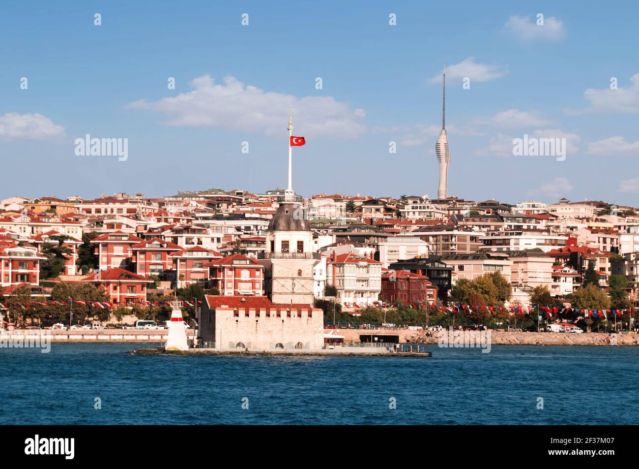 View from the waters of Bosporus Strait on residential blocks of Uskudar neighborhood with legendary Maiden s Tower spire competing with Istanbul TV Stock Photo