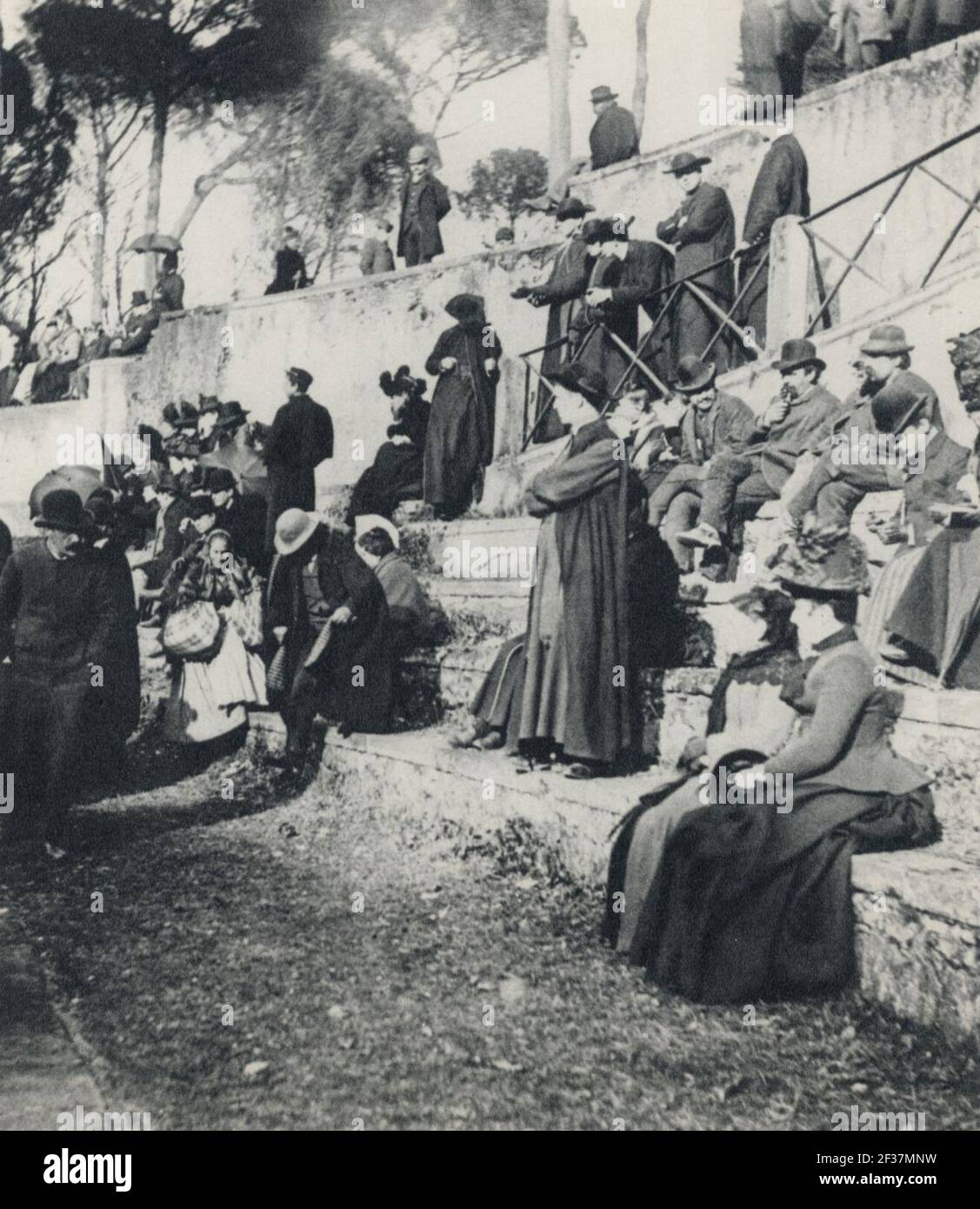 Primoli, Giuseppe - Frauen und Priester in der Sonne auf der Piazza di Siena Stock Photo